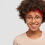 IVision Optical Ethiopia | headshot happy hipster girl with afro haircut satisfied facial expression has delighted kind smile has nostalgia gazes directly stands against white wall free space your text 273609 29116