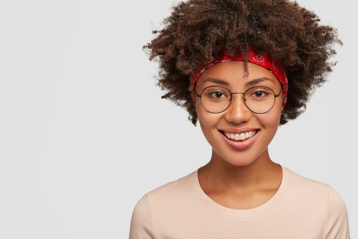 IVision Optical Ethiopia | headshot happy hipster girl with afro haircut satisfied facial expression has delighted kind smile has nostalgia gazes directly stands against white wall free space your text 273609 29116